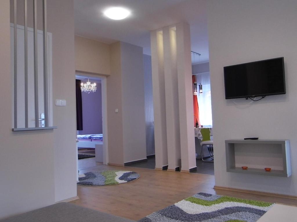a living room with a flat screen tv on a wall at Alfa apartman in Sárvár
