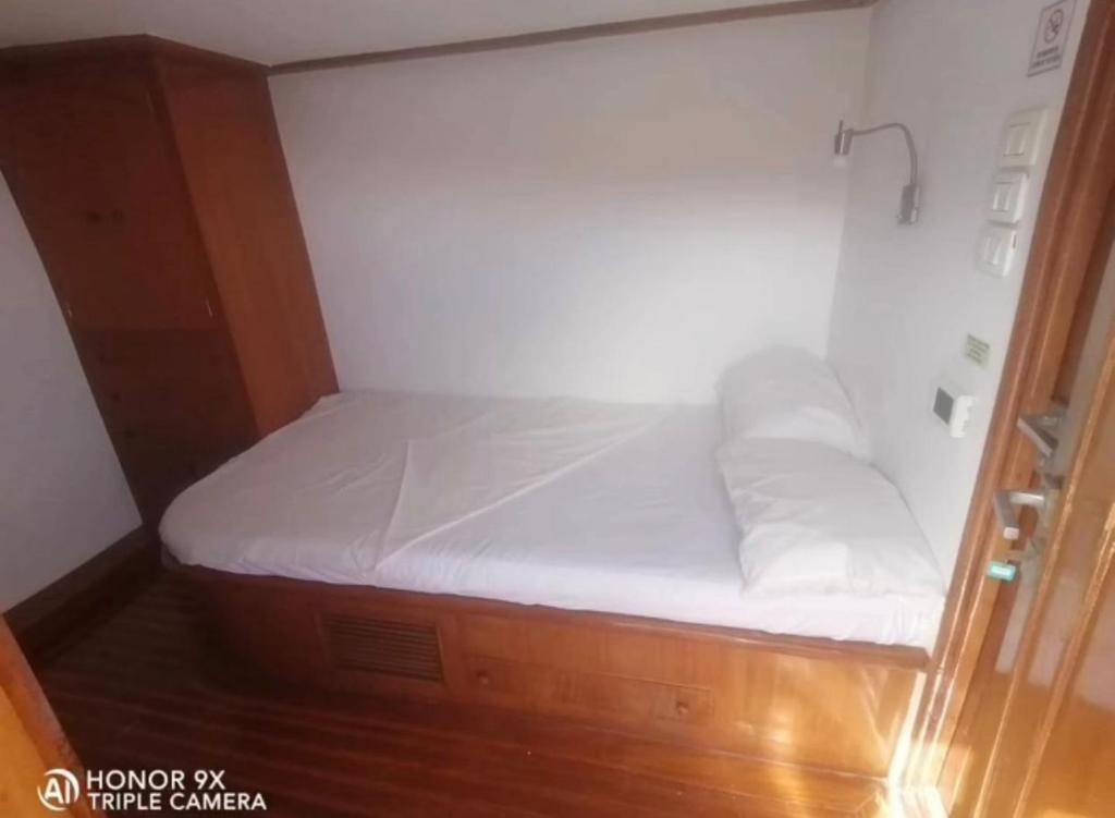 ein kleines Bett in einem kleinen Zimmer mit weißer Bettwäsche in der Unterkunft Tawil 2 in Sharm El Sheikh