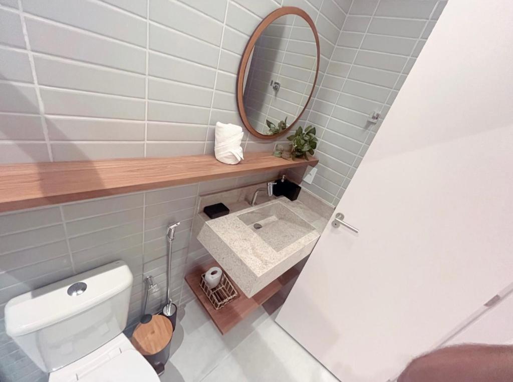 a bathroom with a white toilet and a mirror at Milagres Hospedagens - Praia e Vista Coqueiros in São Miguel dos Milagres