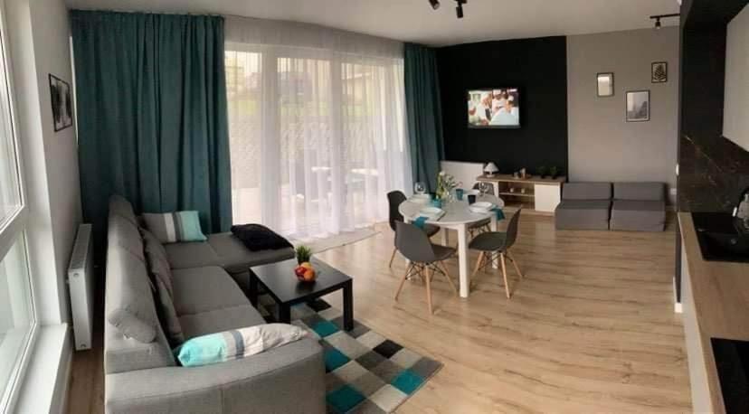 a living room with a couch and a table at Blu Apartament 6 Cetniewo Osada in Władysławowo