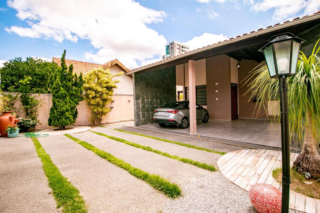 a house with a car parked in the driveway at Casa em Campina Grande in Campina Grande