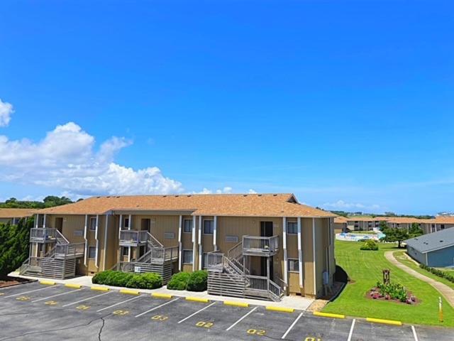a apartment building with balconies in a parking lot at Sea Scape Beach and Golf Villas in Kitty Hawk
