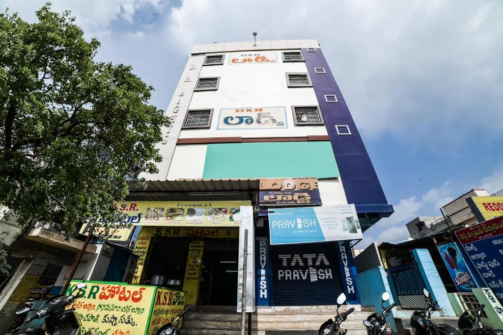 um edifício branco alto com uma frente de loja em OYO Dkr Regency em Kurnool