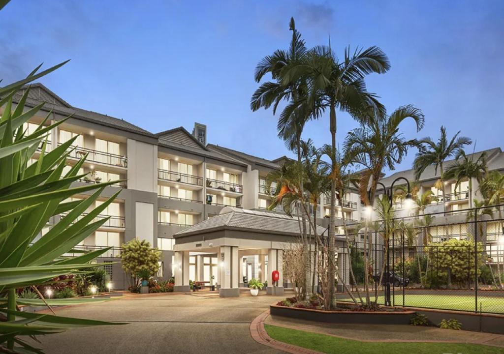 an exterior view of a hotel with palm trees at Paradise Island Resort Surfers Paradise - Garden Suite in Gold Coast