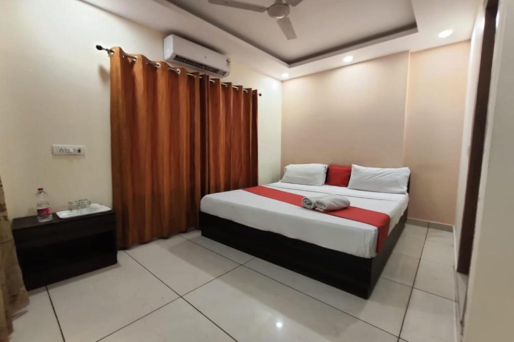 1 dormitorio con 1 cama con cortina roja en OYO Hotel Aerotech, en Nueva Delhi