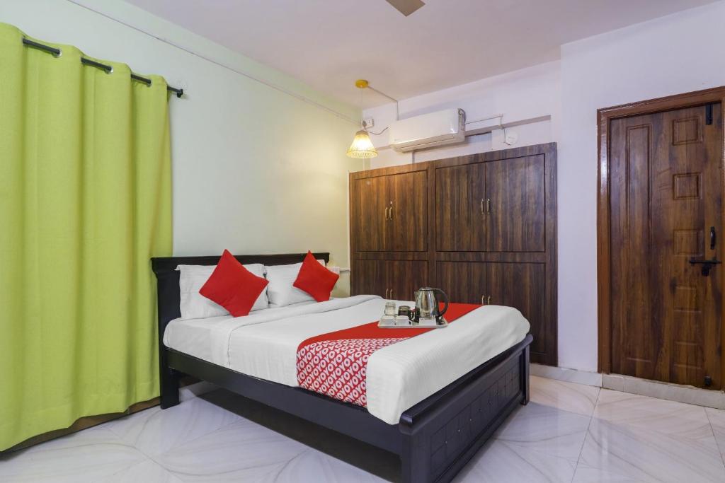 a bedroom with a bed and a green curtain at Super OYO Broholic Hotels Near Botanical Garden in Hyderabad