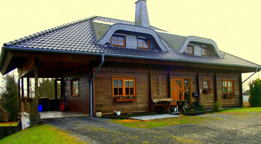 een klein houten huis met een gambrel dak bij Ferien bei Freunden im Holzhaus in Monschau