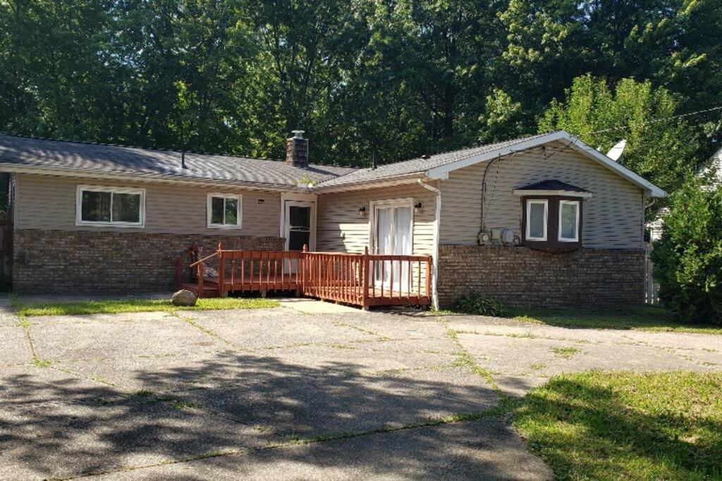 a small brick house with a porch and a wooden gate at "Mentor Place" a 4 bedroom home in the heart of a lake community min away from lot's activities in Mentor