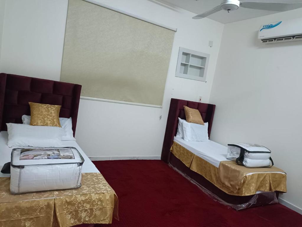 Habitación con 2 camas y mesa. en عابر سبيل عرعر رجال فقط en Arar
