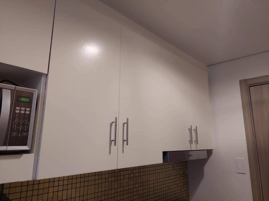 马尼拉Coast Residence 4026 PENTHOUSE 1 Bedroom Condo with Wifi & Netflix的配有白色橱柜和微波炉的厨房