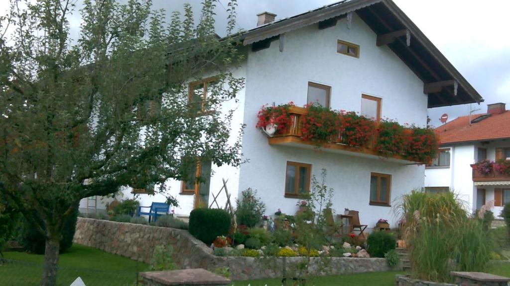 ein weißes Haus mit Blumenkästen drauf in der Unterkunft Ferienwohnung Walter Gluche in Pittenhart