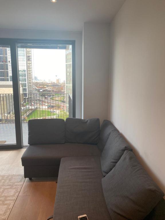 a couch in a living room with a large window at Luxury flat Vauxhall in London