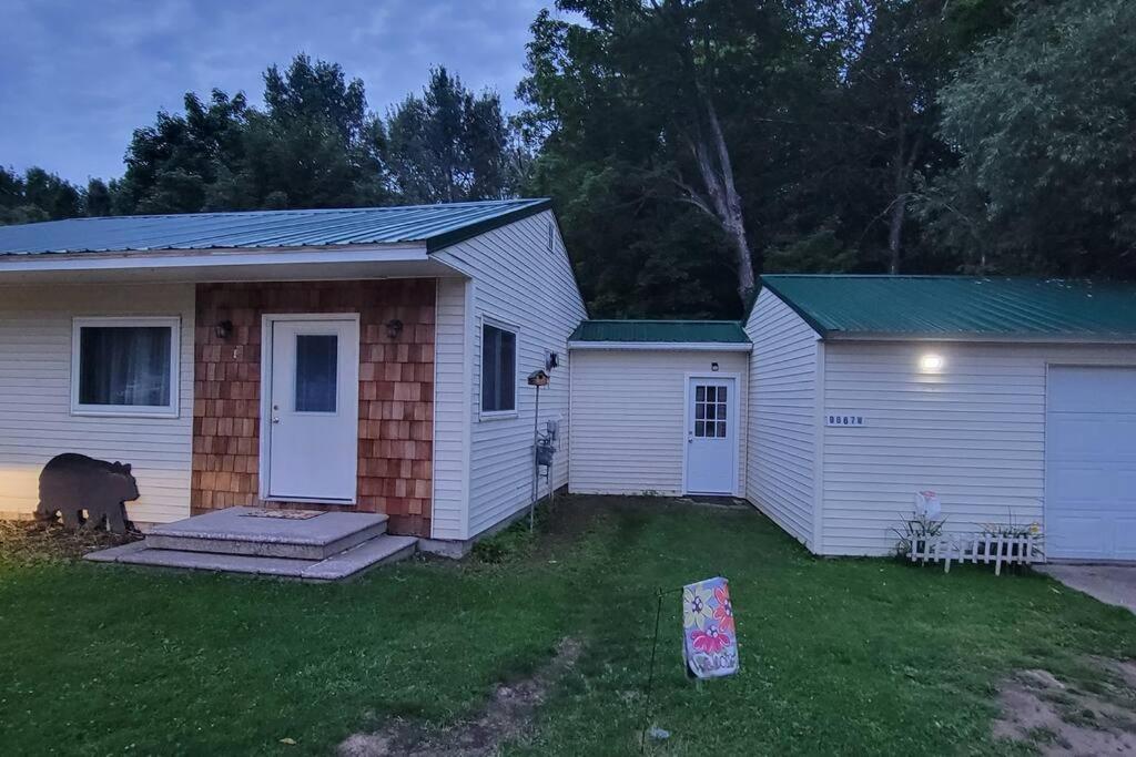 a house with a dog standing outside of it at Newly renovated home with WIFI and ROKU TV in Brimley