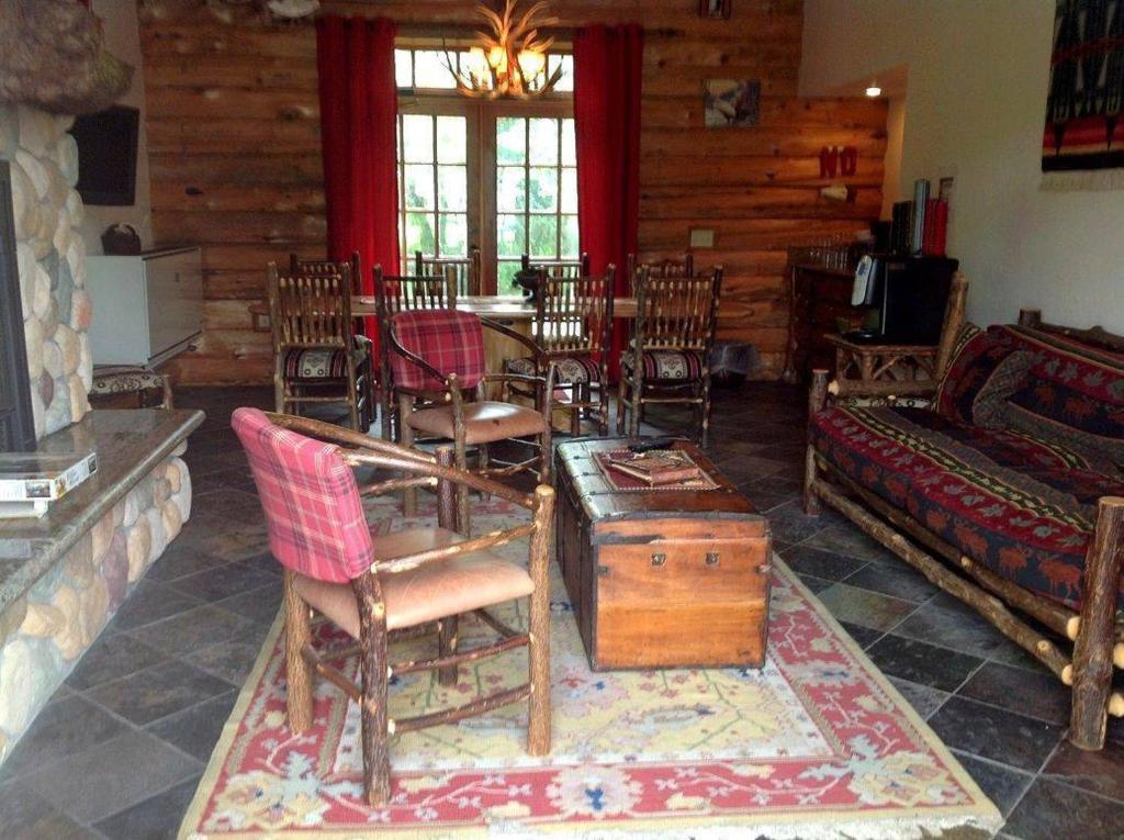 a living room with chairs and a table and a couch at Finger Lakes Lodging in Skaneateles