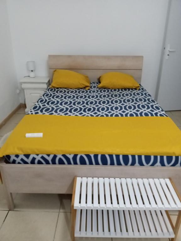 uma cama com lençóis amarelos e azuis e almofadas amarelas em Relax Time Dumanoir em Capesterre-Belle-Eau