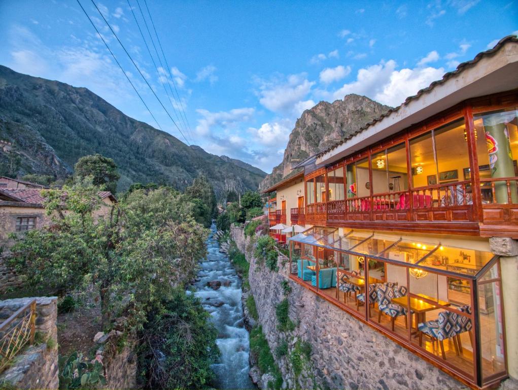 オリャンタイタンボにあるSol Ollantay Exclusive Hotelの川と山の景色を望むホテル