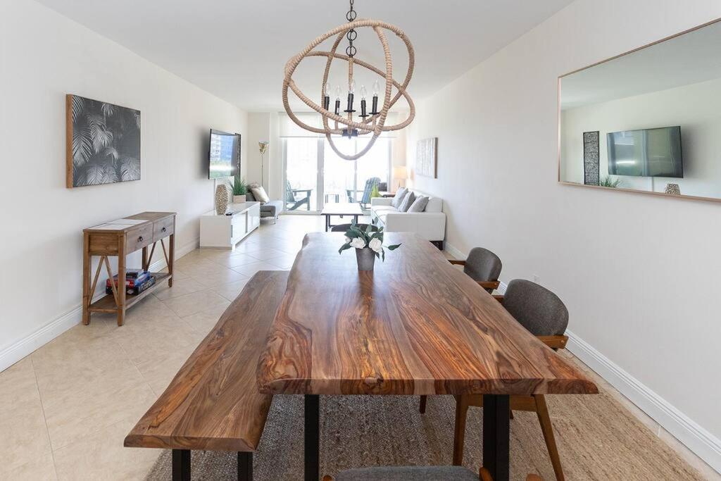 a living room with a wooden table and chairs at Modern Oceanview Condo - Steps to the Beach! in Miami Beach