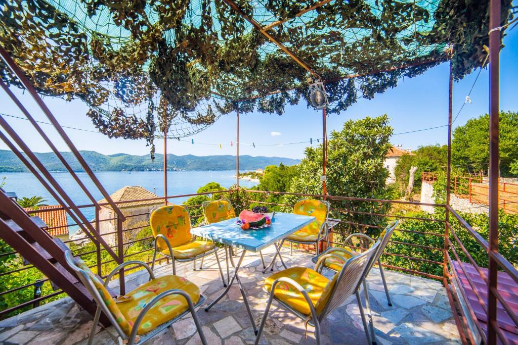 a patio with a table and chairs and a view of the water at Pelješac Apartmani -Orsula in Kučište