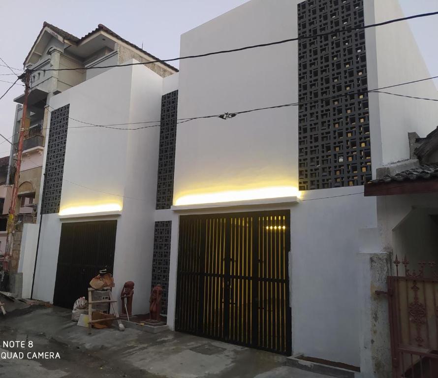 un edificio blanco con una puerta y un edificio en Rumah Bahagia 36 en Bonorejo