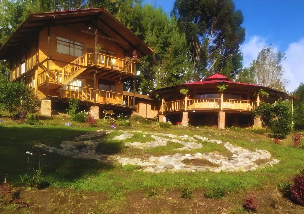 a large wooden house with a large deck at Cozy cabin Casa Enya in Sibundoy