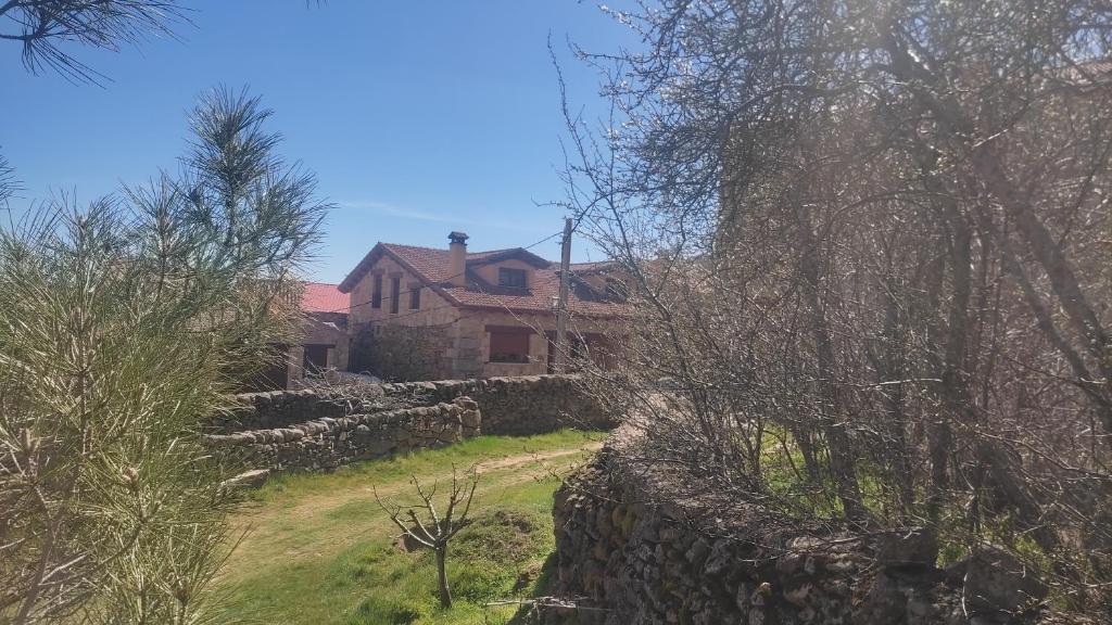 una casa con una valla de piedra y una pared de piedra en Los Arroyos, en San Martín de la Vega del Alberche