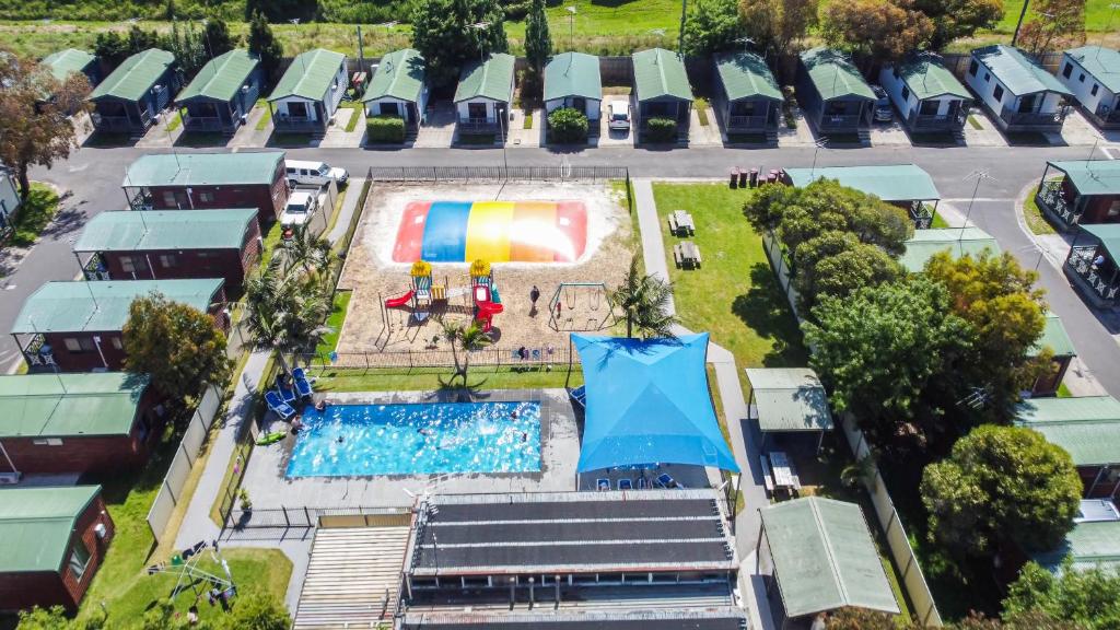 an overhead view of a pool with a rainbow umbrella at Tasman Holiday Parks - Geelong in Geelong