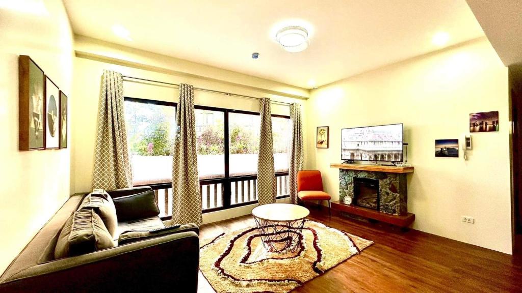 a living room with a couch and a fireplace at BRENT RESIDENCES BAGUIO in Baguio