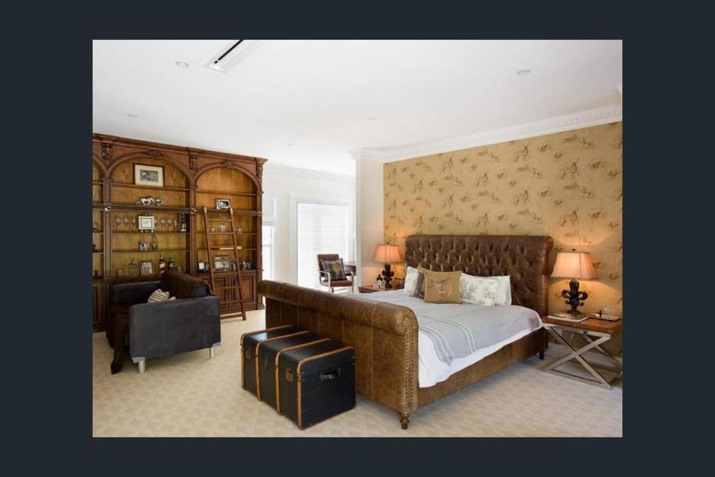 Sarabah Estate Vineyard & Villa في Beechmont: غرفة نوم بسرير كبير وكرسي