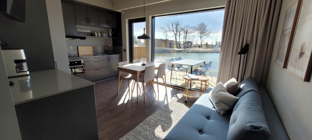 uma sala de estar com um sofá e uma cozinha com vista em Halmstad Golfarena Hotell & Lägenheter em Halmstad