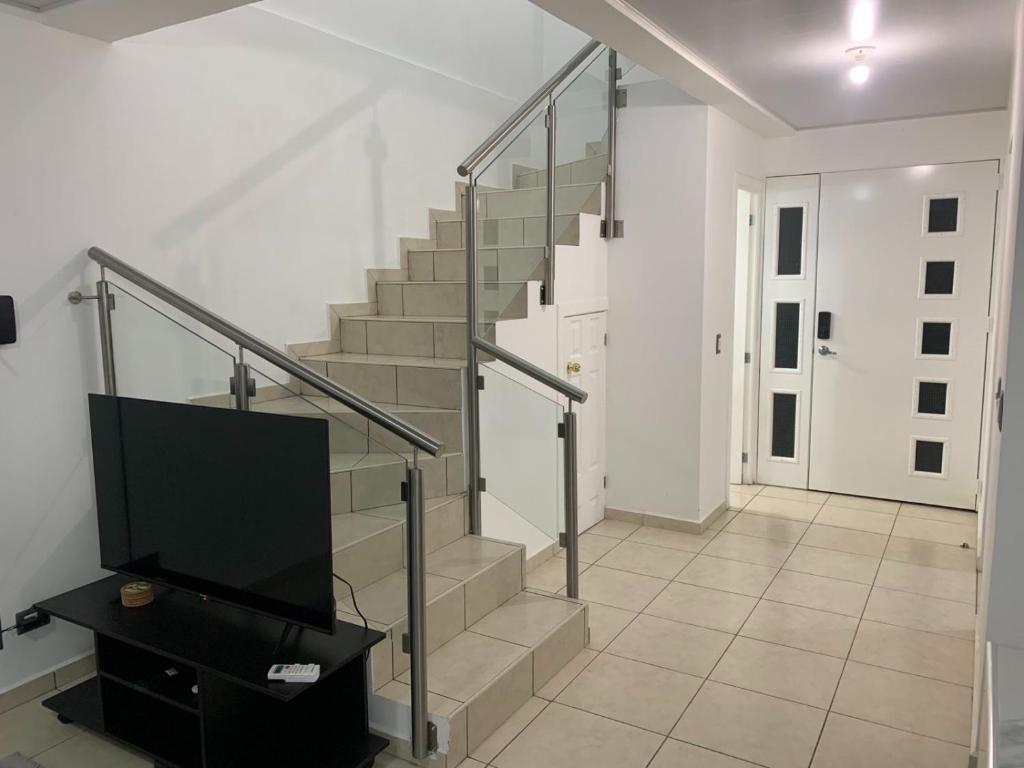 a staircase with a flat screen tv in a living room at Comfortable and roomy, in Sonsonate in Sonsonate