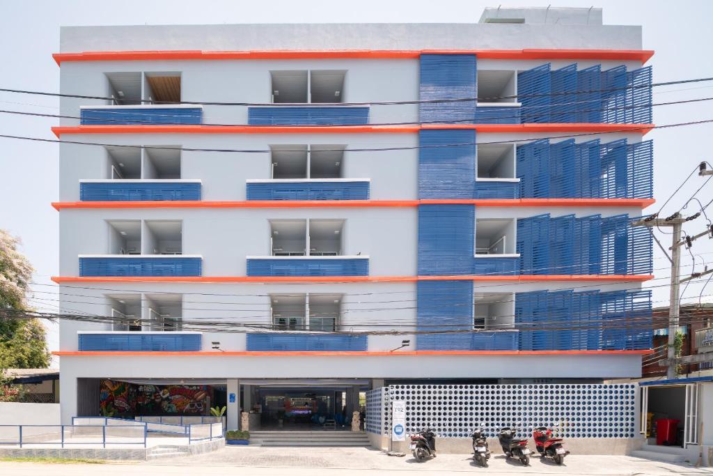 an apartment building with blue and red balconies at Akira Pattaya in Jomtien Beach
