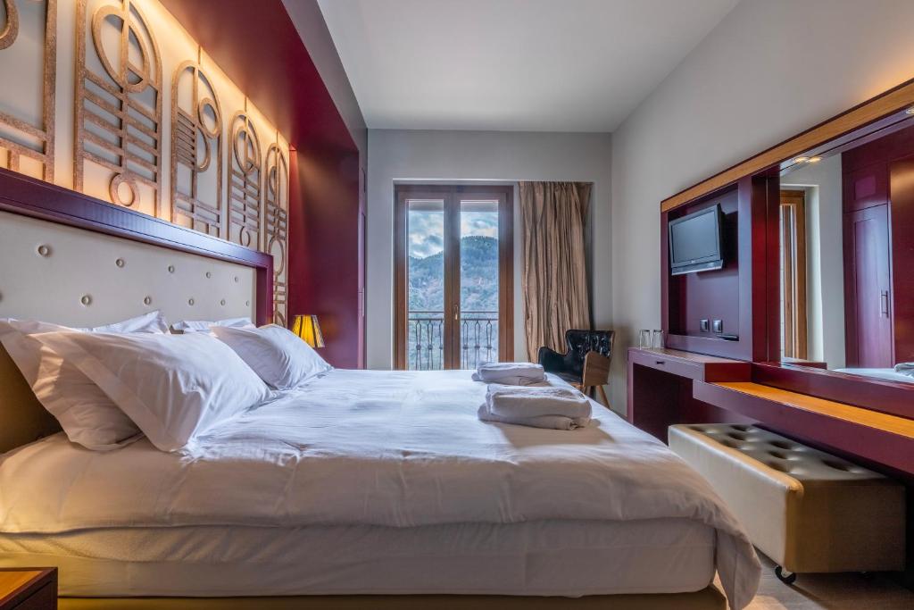 sypialnia z dużym łóżkiem i telewizorem w obiekcie Lagadia 4 Seasons Hotel w mieście Lagkadia