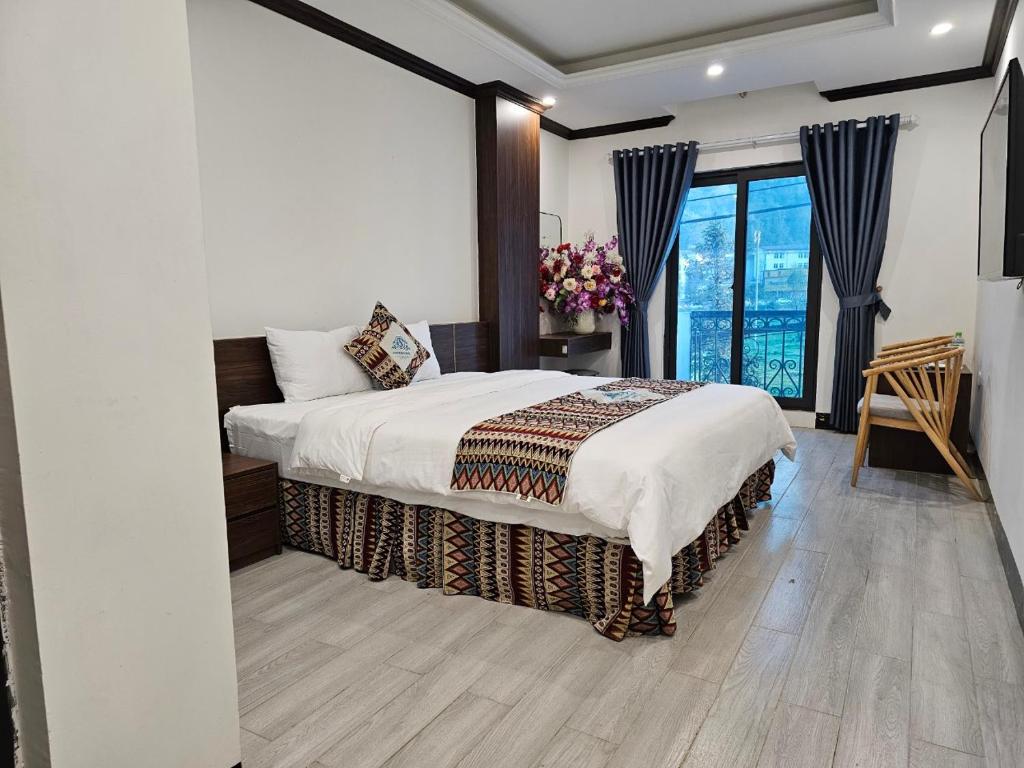 a bedroom with a bed and a large window at SAPA COSY HOTEL in Sa Pa