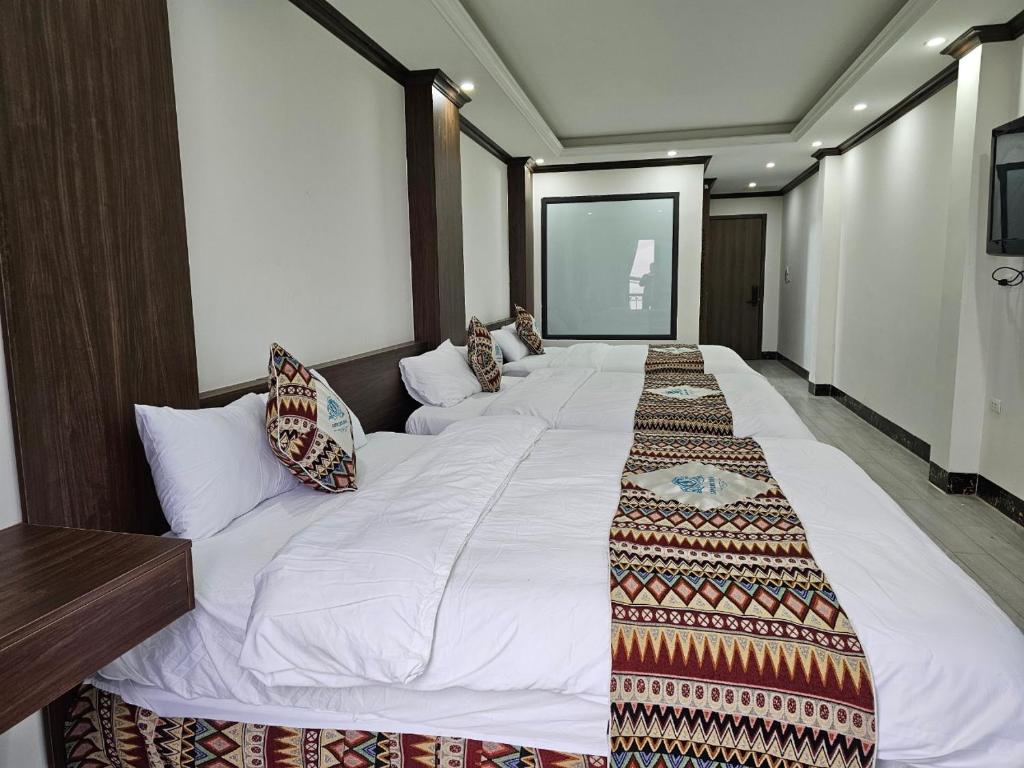 een groot wit bed in een hotelkamer bij SAPA COSY HOTEL in Sa Pa