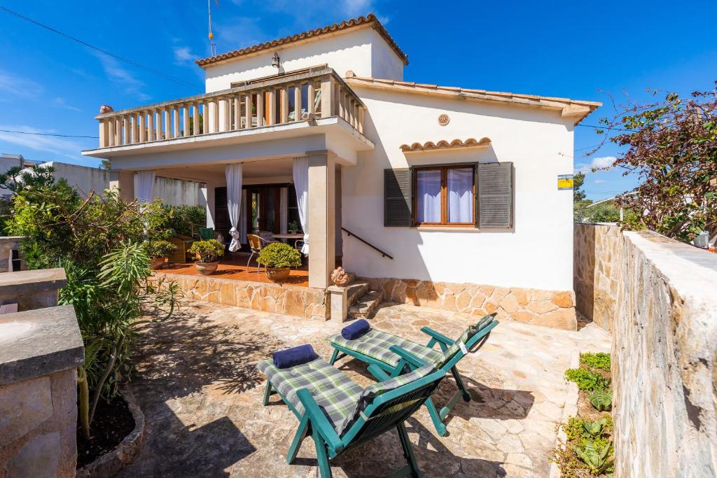 a villa with a table and chairs in front of a house at Casa Can Pinyol in Cala Figuera