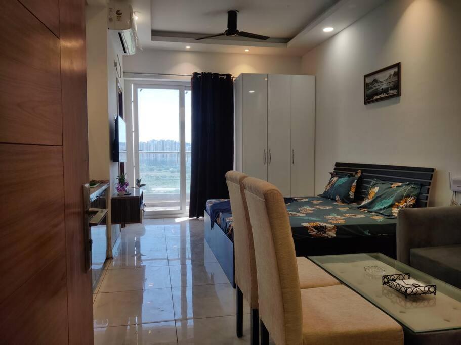 um quarto com uma cama, uma mesa e uma sala de jantar em Minimalistic High Rise Stay-Couple Friendly em Noida