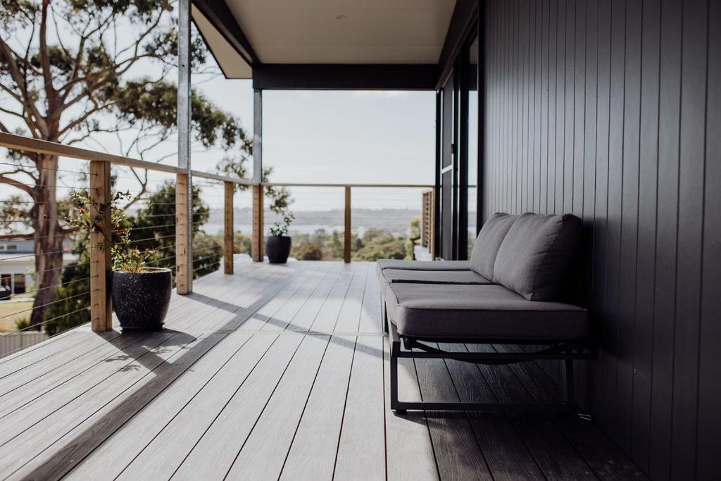 a porch with a couch on a wooden deck at Bayview Lodge - Views Views Views! in St Helens