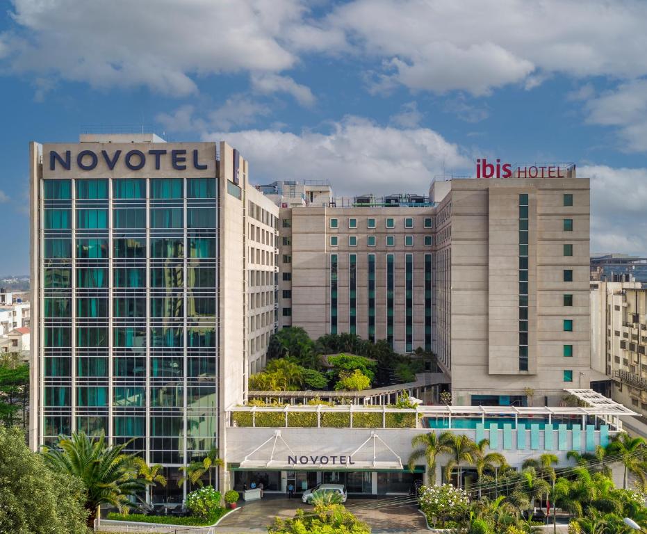 um grande edifício com um hotel hbos em cima dele em Novotel Bengaluru Outer Ring Road em Bangalore