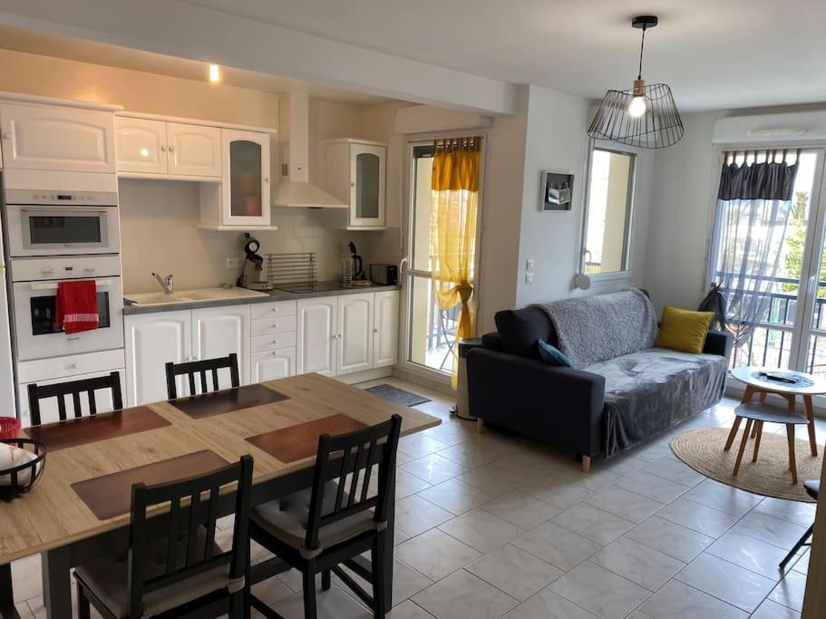 eine Küche und ein Wohnzimmer mit einem Sofa und einem Tisch in der Unterkunft Appartement Avenue de Champagne in Épernay