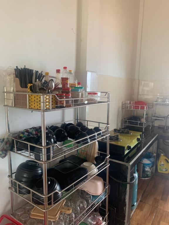a kitchen with a shelf filled with pots and pans at Retro Khe Sanh in Lao Bao