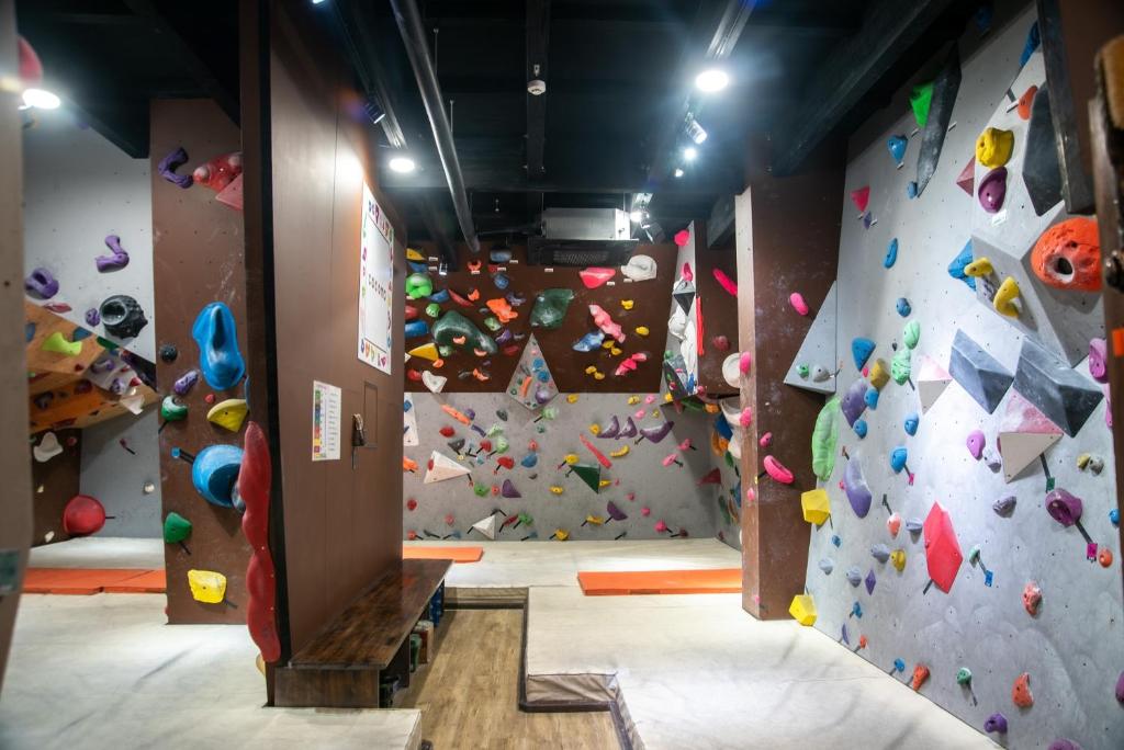 une salle avec un mur d'escalade et une salle de sport d'escalade dans l'établissement CLIMB INN COCOMO, à Sumoto