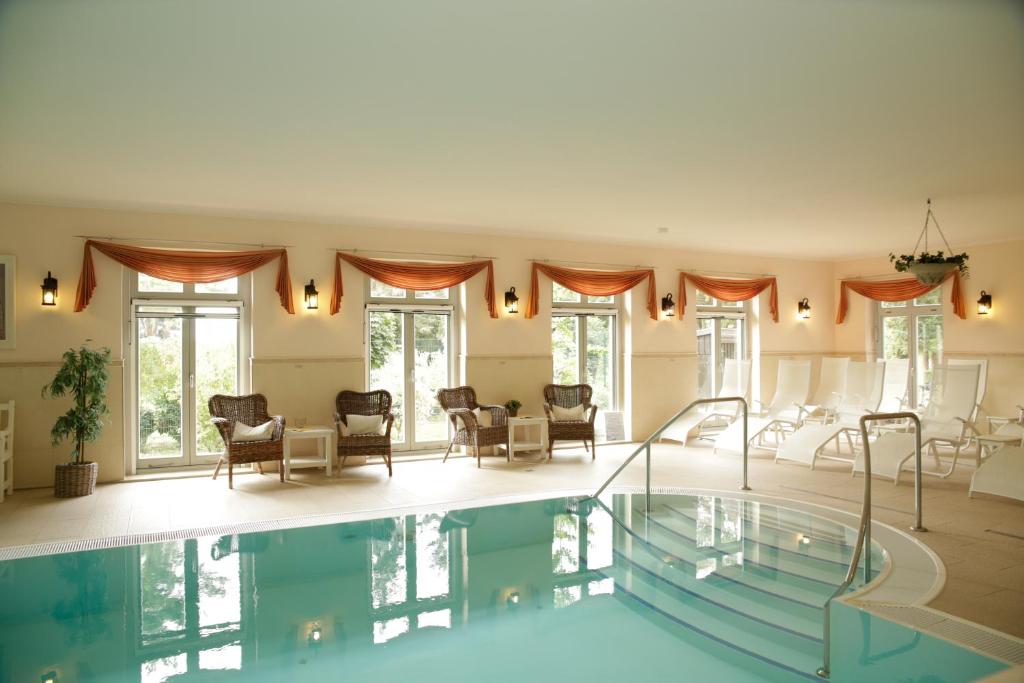 a large swimming pool in a living room with chairs at Ringhotel Schloss Tangermünde in Tangermünde