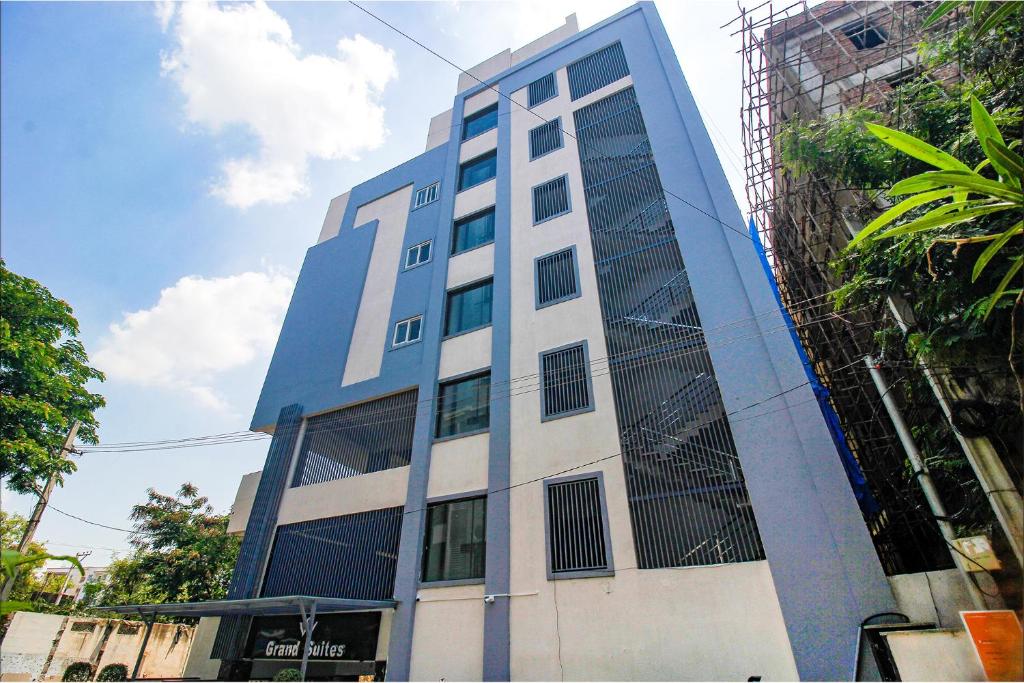 ein hohes blau-weißes Gebäude mit Gerüst in der Unterkunft FabHotel W Grand Suites in Hyderabad