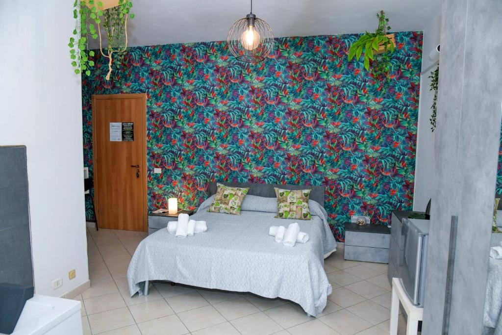 サンタ・マリア・ディ・カステッラバーテにあるB&B Damianiのカラフルな壁のベッドルーム1室