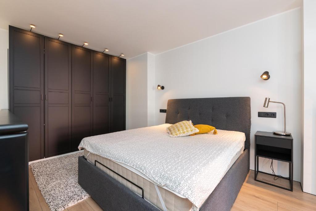 a bedroom with a large bed and a black closet at Hilltop Apartments - Ilmarine district in Tallinn