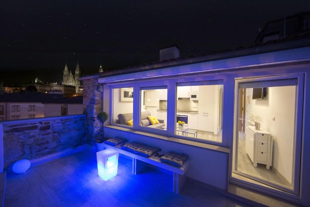 a balcony with a couch and a window at night at Bolboreta Dreams Apartamentos Turísticos in Santiago de Compostela