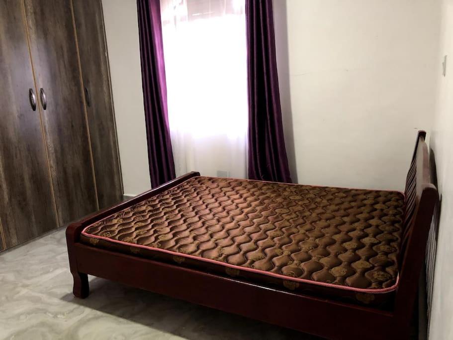 a brown bed in a room with a window at Aberdare Home in Othaya