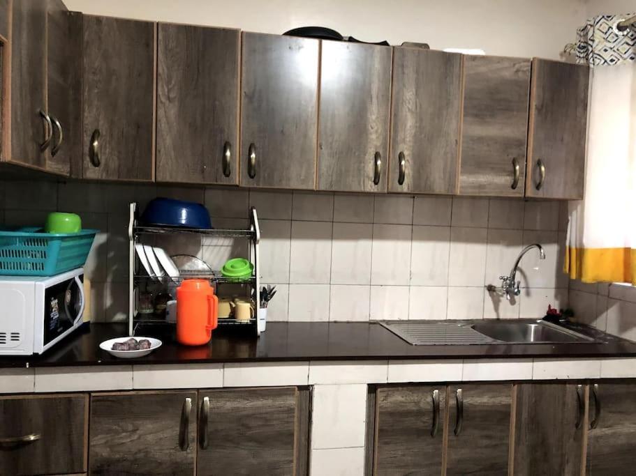 a kitchen counter with a sink and a microwave at Aberdare Home in Othaya