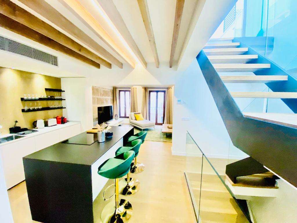 a large kitchen with a staircase and green chairs at Hotel-Apartment with big terrace in Palma de Mallorca