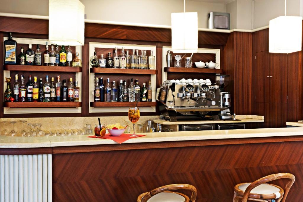 a bar in a hotel room with a counter and chairs at Hotel Spinelli in Viareggio